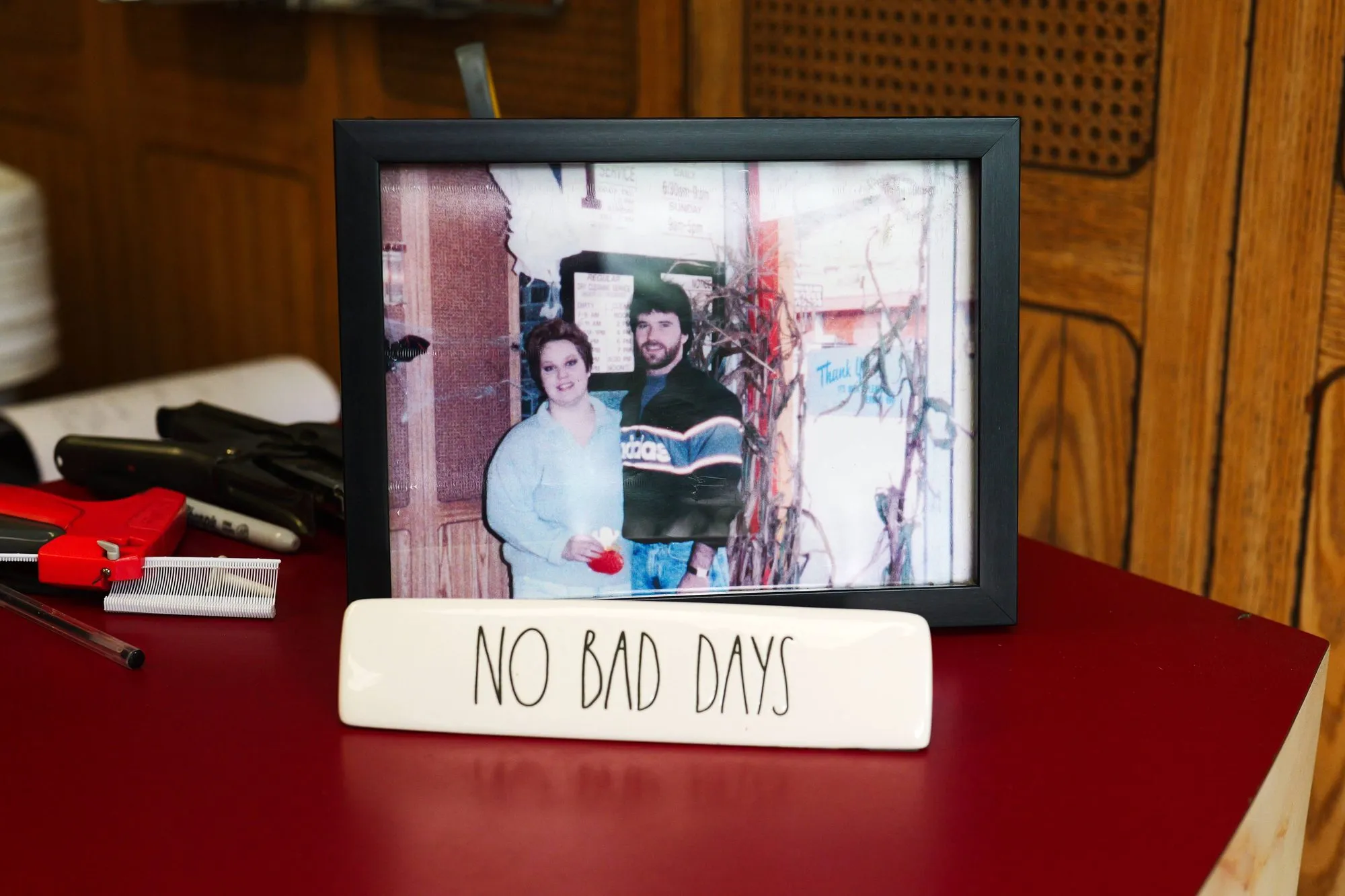 A framed old photograph of the family on a shelf beside a small hand-painted sign reading NO BAD DAYS.