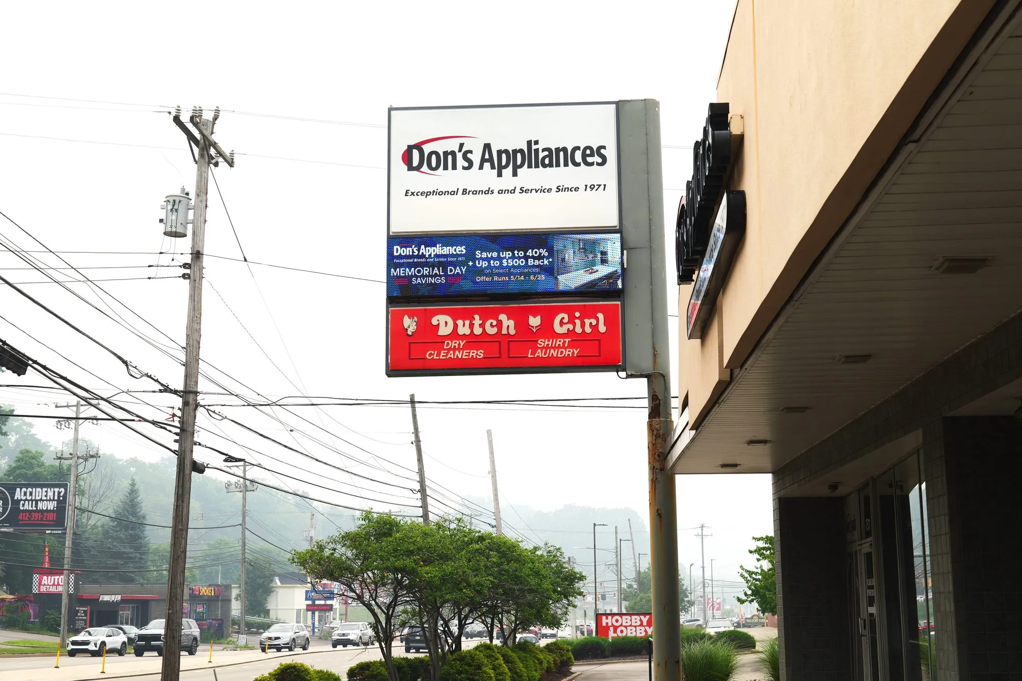 The Dutch Girl Cleaners roadside pole sign on the commercial strip, seen from the road.